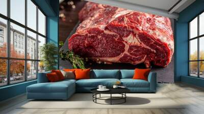 Raw meat. Beef tenderloin, neck lies on a black board, next to a knife and knife sharpener. closeup. background image. copy space Wall mural