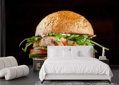 Vegetarian American Cuisine. Burger with red fish salmon, arugula, cucumbers and tomatoes, white sauce. Burger on a black background. background image, copy space text Wall mural