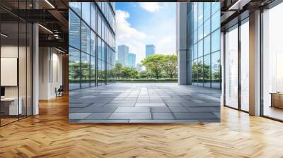 Empty tiled walkway between two modern glass buildings with a city skyline reflected in the windows, against a blue sky with white clouds. Wall mural