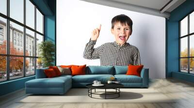 Portrait of stylish little boy with finger pointed up. Little child has idea. Kid isolated on white blackboard. Success, bright idea, creative ideas and innovation technology concept. Wall mural