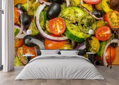 Healthy vegetable salad of fresh tomato, cucumber, onion, black olives,yellow sweet pepper with basil pesto sauce on wooden bowl.Top view, copy space.  Wall mural