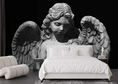 Antique statue of sad angel isolated on black background. Wall mural