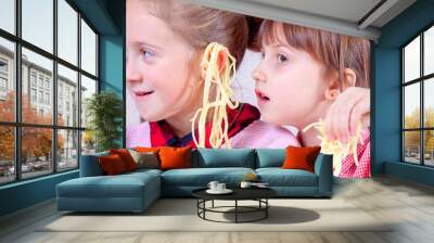 Noodles on the ears as symbol of deception and lies. Funny image of two little cute child girlfriends are cheating on each other. Wall mural