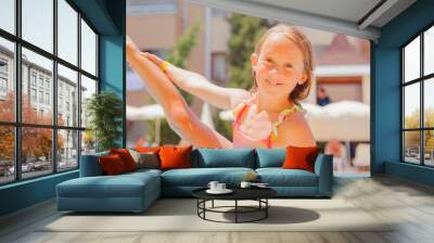 Summer vacation and healthy lifestyle and happy childhood concept. Portrait of child having fun in swimming pool. Kid playing outdoors. Wall mural