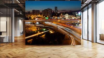 City highway traffic - street with fast moving cars and lights trails - long exposure. Warm illumination at night. Rush hour, urban, transportation and city life concept Wall mural