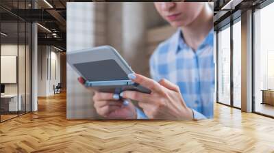 Gaming, hobby, technology, portable, entertainment, video game and leisure time concept. Woman using grey handheld game console at bright living room - close up view Wall mural