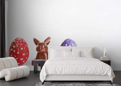 A rabbit between two Easter eggs on a white background. Wall mural