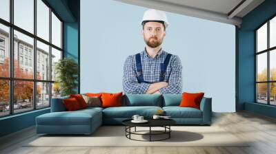 Confident construction worker in a white helmet and blue overalls Wall mural