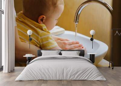 Little toddler boy and his mother wash hands in bathroom sink Wall mural