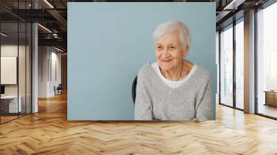 Portrait of elderely grey haired woman in a comfortable sweater at home Wall mural