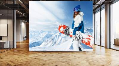 happy laughing girl with a red snowboard on a background of peaks alpine mountains Wall mural