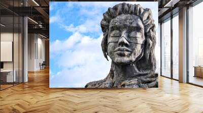 A huge plaster sculpture of a woman against the sky. Wall mural