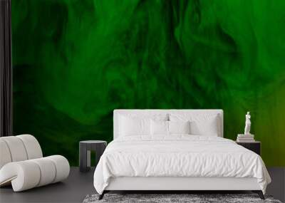 swirling clouds of green and yellow smoke randomly mix on a black background Wall mural