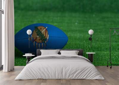 American football ball  with Oklahoma flag on green grass background, close up Wall mural