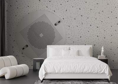 A round white speaker with a mesh is fixed to the white ceiling tile with screws. Wall mural