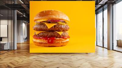 Delicious burger with double beef and cheddar cheese on a yellow background. Tasty fresh unhealthy burgers with cheese and two patties. Fast food, unhealthy food concept. Wall mural