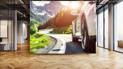 close-up of a modern car driving fast along a serpentine road in the mountains in the rays of the sun Wall mural