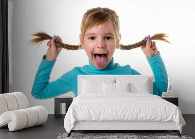 Cheerful girl making funny face. Portrait of emotionally kid. Funny little girl isolated on white background. Beautiful caucasian model with two braids Wall mural