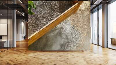 A construction truck is dumping crushed stone at a construction site. A close-up shows a working moment of unloading materials at a construction site. Wall mural