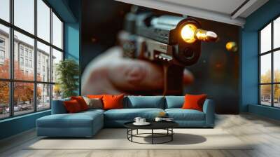 A handgun with a flying bullet. A hand holding a gun on a blurry background Wall mural