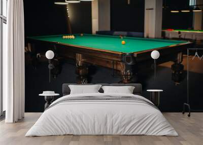 Billiard table with green surface and balls in the billiard club. Wall mural