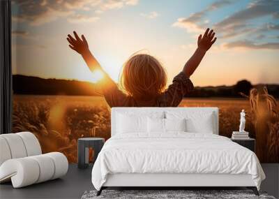 A little boy raises his hands above the sunset sky, enjoying life and nature. Happy kid on a summer field looking at the sun. Silhouette of a male child in the sun. Fresh air, environment concept.	
 Wall mural