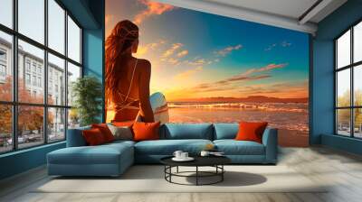 Back view of beautiful young woman surfer girl with white surfboard on the beach at sunset or sunrise Wall mural