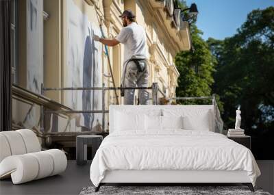 Worker painting and restoring the exterior of a historic building on scaffolding. Wall mural