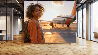 Young woman smiling at airport with airplane in background Wall mural