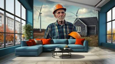 An elderly coal worker reflects on his retirement holding a helmet in front of his house amid wind turbines in the background Wall mural