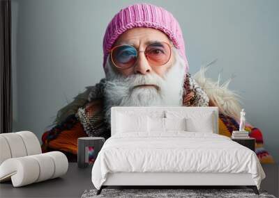 Studio shot of serious senior man with white beard in colorful winter outfit with sunglasses Wall mural