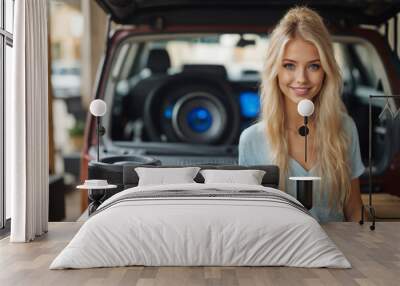 A beautiful blonde girl at an auto sound competition. Car music. Subwoofers, amplifiers, acoustics. Car audio system. Wall mural