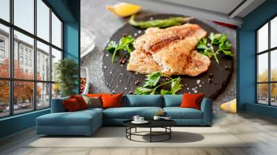 Baked white fish fillet Pangasius with spices and lemon on a stone background Wall mural