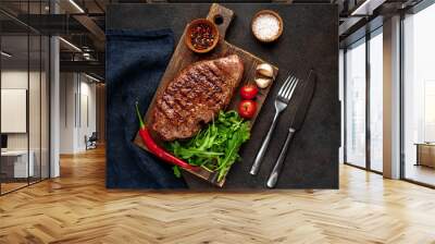 grilled beef steak with spices and herbs on a cutting board on a stone background Wall mural