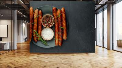 Grilled sausages on a plate with spices and rosemary on a stone table Wall mural