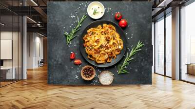 Pasta Bolognese with spices, Italian pasta dish with minced meat and tomatoes in a dark plate on a stone background Wall mural