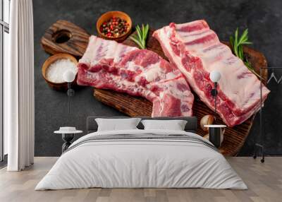 raw pork ribs with spices on a cutting board on a stone background Wall mural