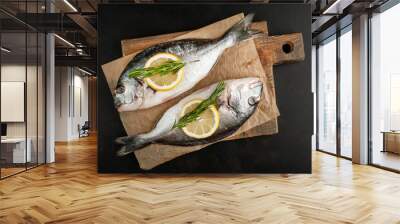 two fresh raw Dorado fish on a cutting board with spices and olive oil on a stone background Wall mural