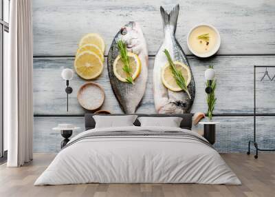 Two fresh raw Dorado fish with spices and olive oil on a wooden table. Wall mural