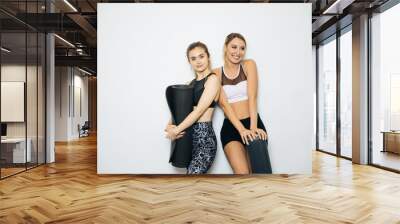 On a white background posing in a sports hall,Young sports girls are engaged in fitness, lifestyle, sports and healthy eating, in the gym girls do exercises Wall mural