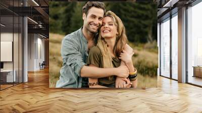 Loving young couple hugging and smiling together on nature background Wall mural