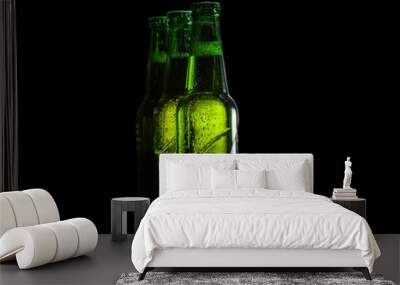 Green glass beer bottles on a black background. Wall mural