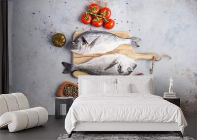 Fish dishes cooking preparation with dorado in backing form in shape of fish with healthy vegetables on gray background with ingredients, top view Wall mural