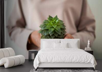 The girl is engaged in the cultivation of domestic plants and flowers. This is her hobby and work. In the photo, the girl is holding a plant that she has grown. Wall mural