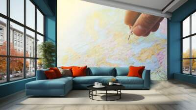 pushpin in hand over a blurred world map Wall mural