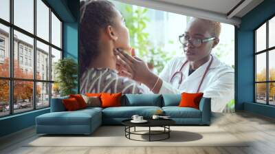 african female doctor watching patient with sore throat Wall mural