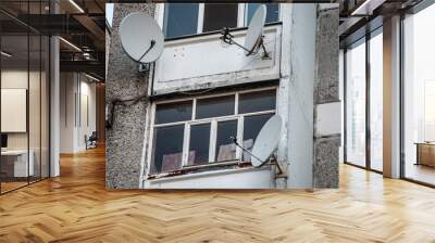 round TV antennas near the window on a bright building Wall mural