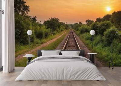 The sun is slowly setting behind the distant train tracks in view Wall mural