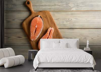 Composition with salmon steaks on the background of a wooden table with copy space. Wall mural