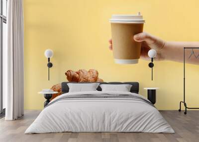 Two croissants and a hand with a paper cup for coffee and tea Wall mural